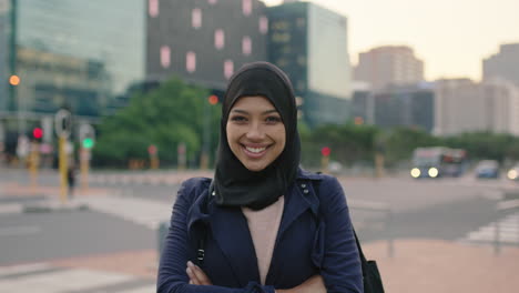 portrait of young muslim business woman executive laughing cheerful at camera on city street arms crossed urban commuter