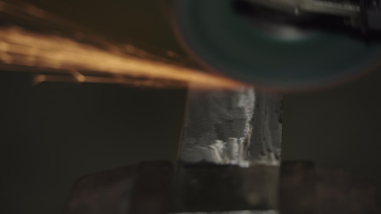 많은 불꽃을 일으키는 건설 각 밀러에서 작업자의 클로즈업