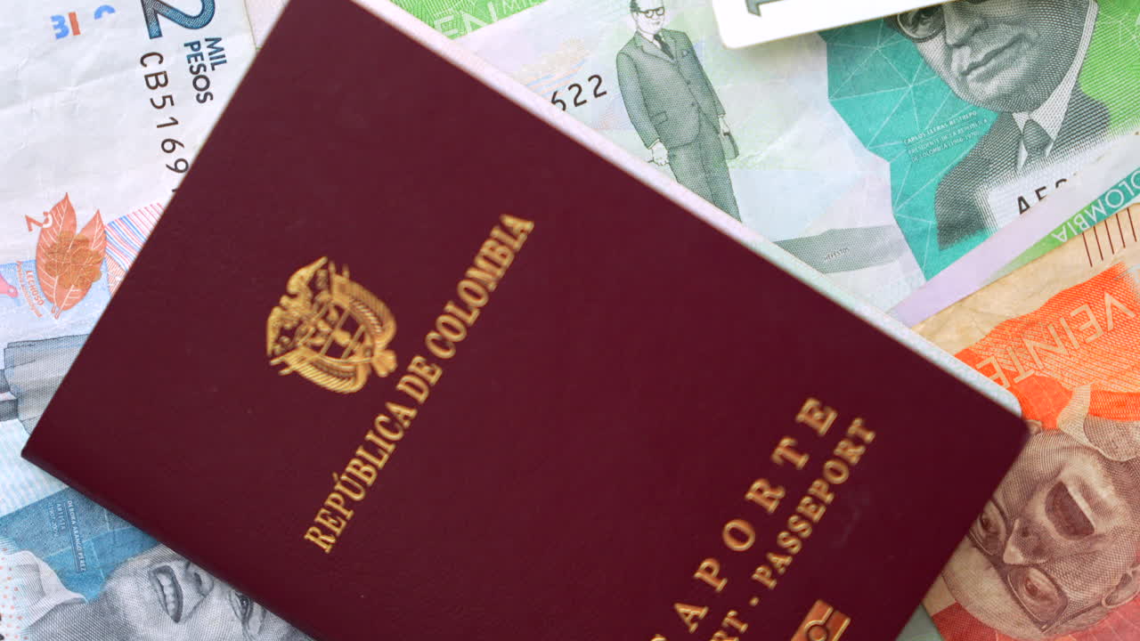 Detailed close-up of a Colombian passport resting on various denominations of local currency, capturing vibrant colors and textures under soft lighting, perfect for finance and travel themes