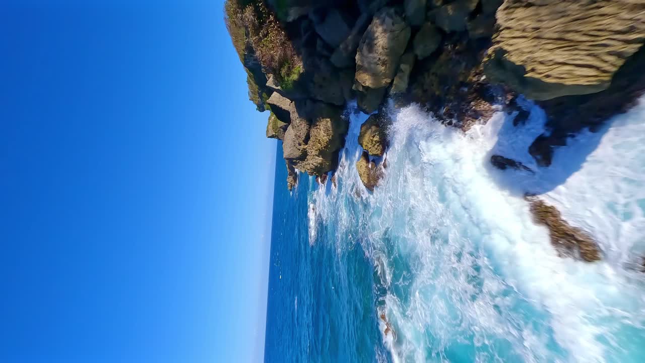 vuelo fpv sobre la costa ondulada del mar caribe durante un día soleado en cabo frances viejo, maria trinidad sanchez