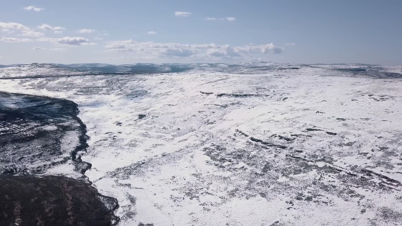 Riprese aeree di paesaggio innevato in Lesotho, Africa. Nevicata in Africa. Auto che guida su strade in un paesaggio innevato.