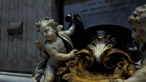 Statue-of-2-Angels-made-of-marble-shot-in-Saint-Peter's-Basilica-in-the-Vatican,-the-papal-enclave-which-is-within-the-city-of-Rome