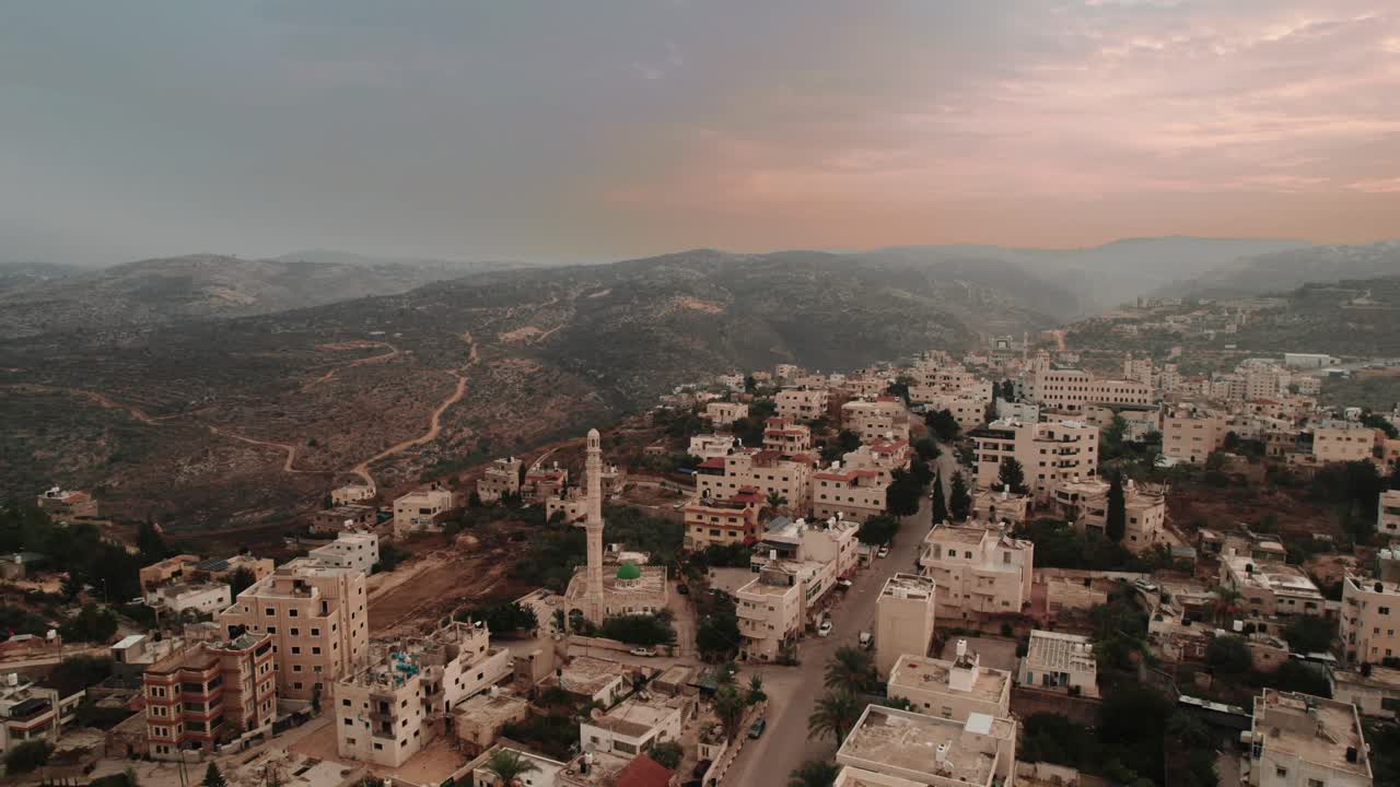 imágenes de cámara aérea de una ciudad con una mezquita y colinas circundantes en jerusalén
