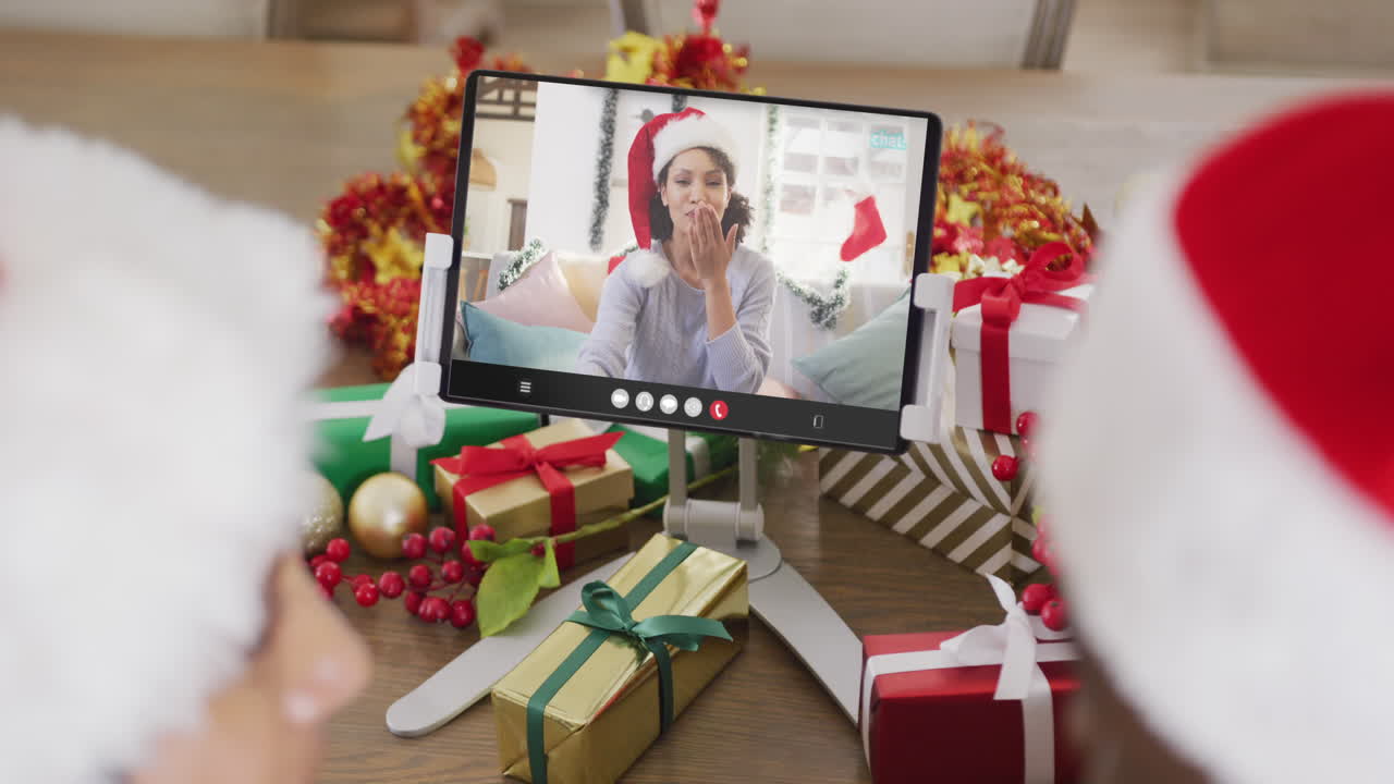 una pareja diversa tiene una videoconferencia de navidad con una mujer afroamericana.
