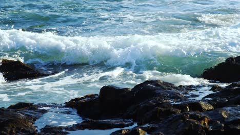 las olas salpican sobre la roca ion el mar 4k