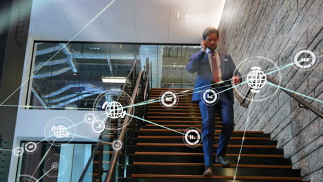 network of digital icons against caucasian businessman climbing down the stairs at office