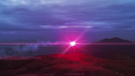 the man holds a fire smoke on the mountain top