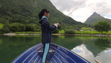 Frau-Auf-Dem-Boot-Fängt-Einen-Fisch-Beim-Spinnen-In-Norwegen.