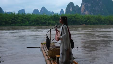 beautiful hanfu girl holding a pipa during a photo session in li river, xingping