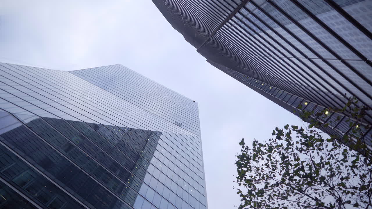 Tilt up shot of big glass skyscrapers in the city of London.