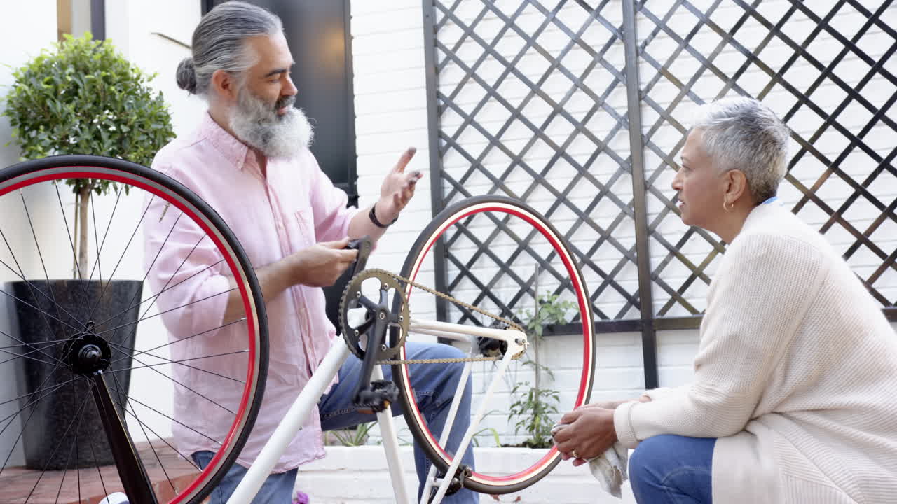 Repairing bicycle, senior couple discussing maintenance in outdoor area