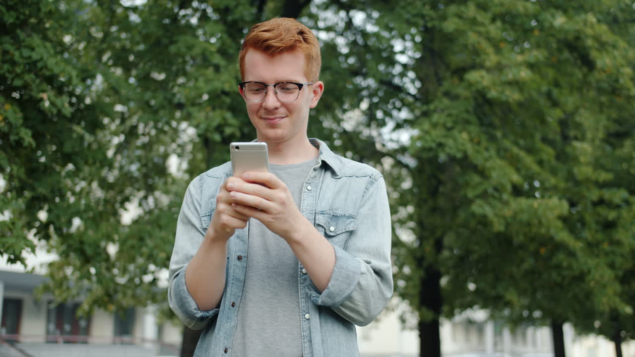 밖에서 스마트폰을 사용하는 젊은 남자