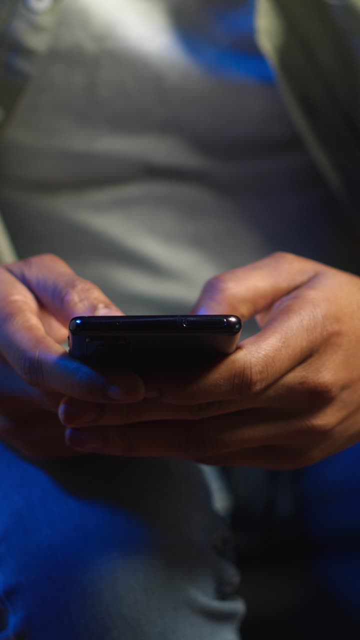 Vertical Video Casual african american man browsing on his smartphone in a comfortable space