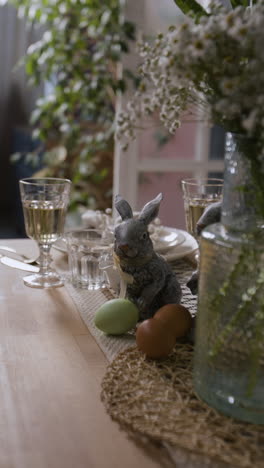 configuración de la mesa de pascua con estatuillas de conejo y huevos