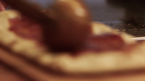 alguien está aplicando salsa de pizza a una pieza de pan plano