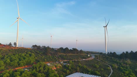 wind power hill with rotating blades in the morning sunlight in da lat - vietnam | wind power