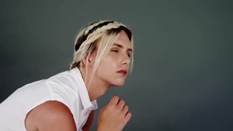 androgynous man posing against green background