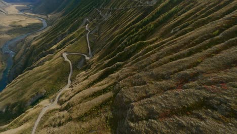 fpv sports drone black car riding on dangerous serpentine road with sharp turns mountain nature