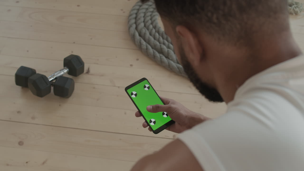 Fit Man With Smartphone At Gym