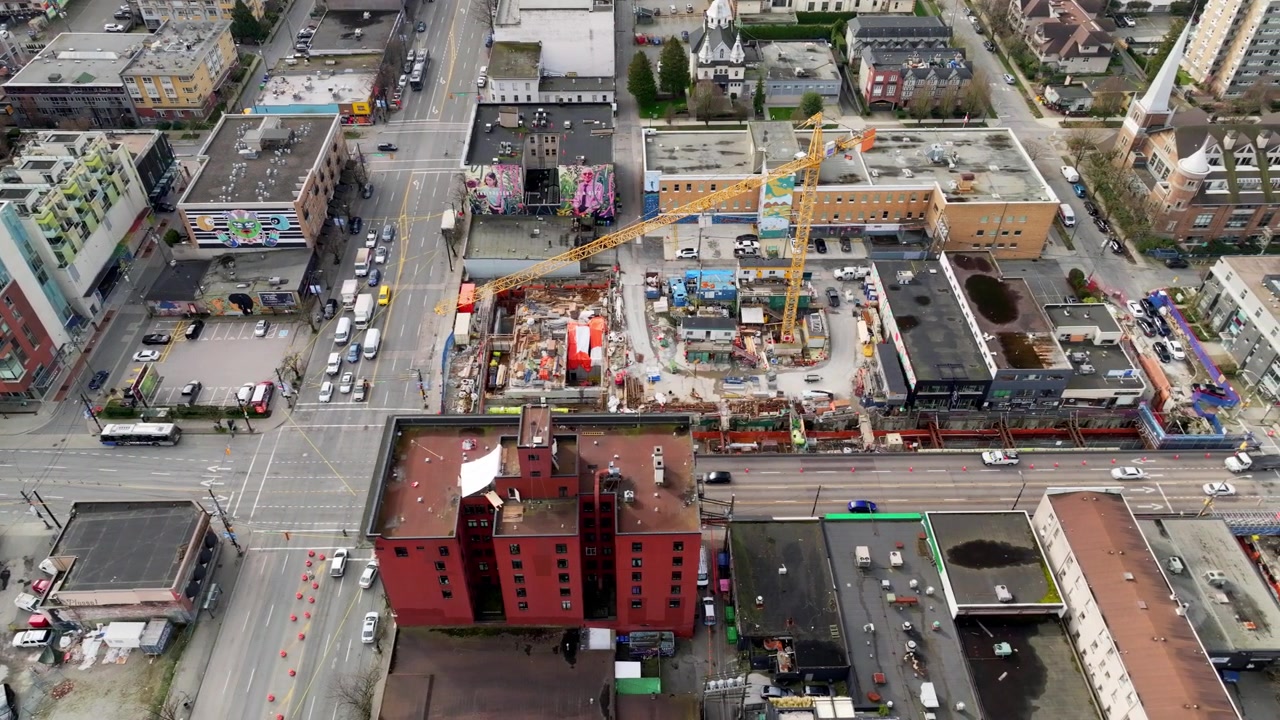 Ongoing Broadway Line SkyTrain Construction With Cranes, Traffic, and City Buildings - Main Street to Cambie Street, Vancouver, Canada - Aerial Drone Shot