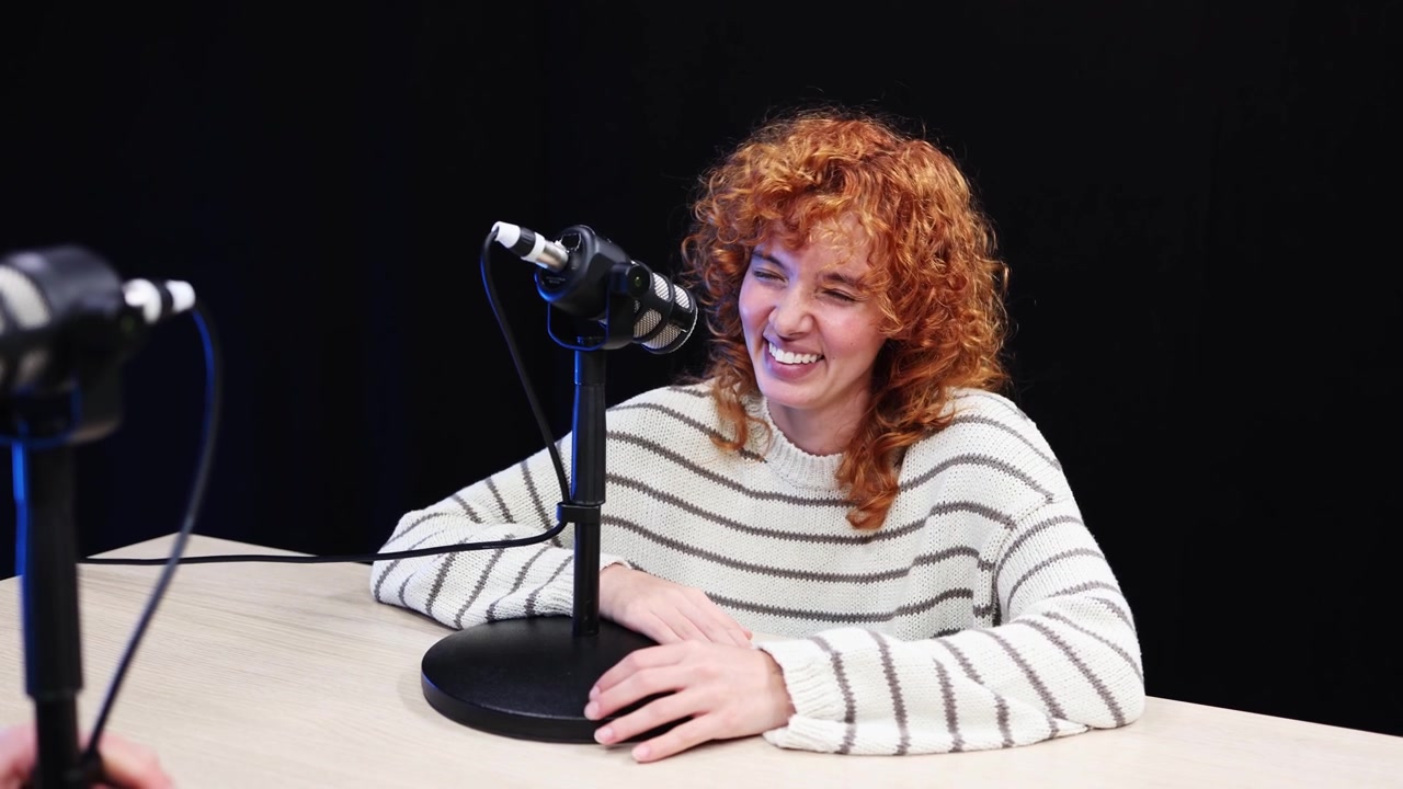 Giovane donna felice che parla e ride durante un'intervista podcast