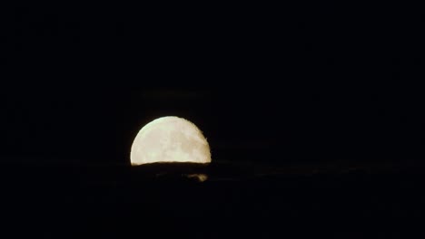 dramatic low moon rise through thin cloud layer time lapse strong air disturbance