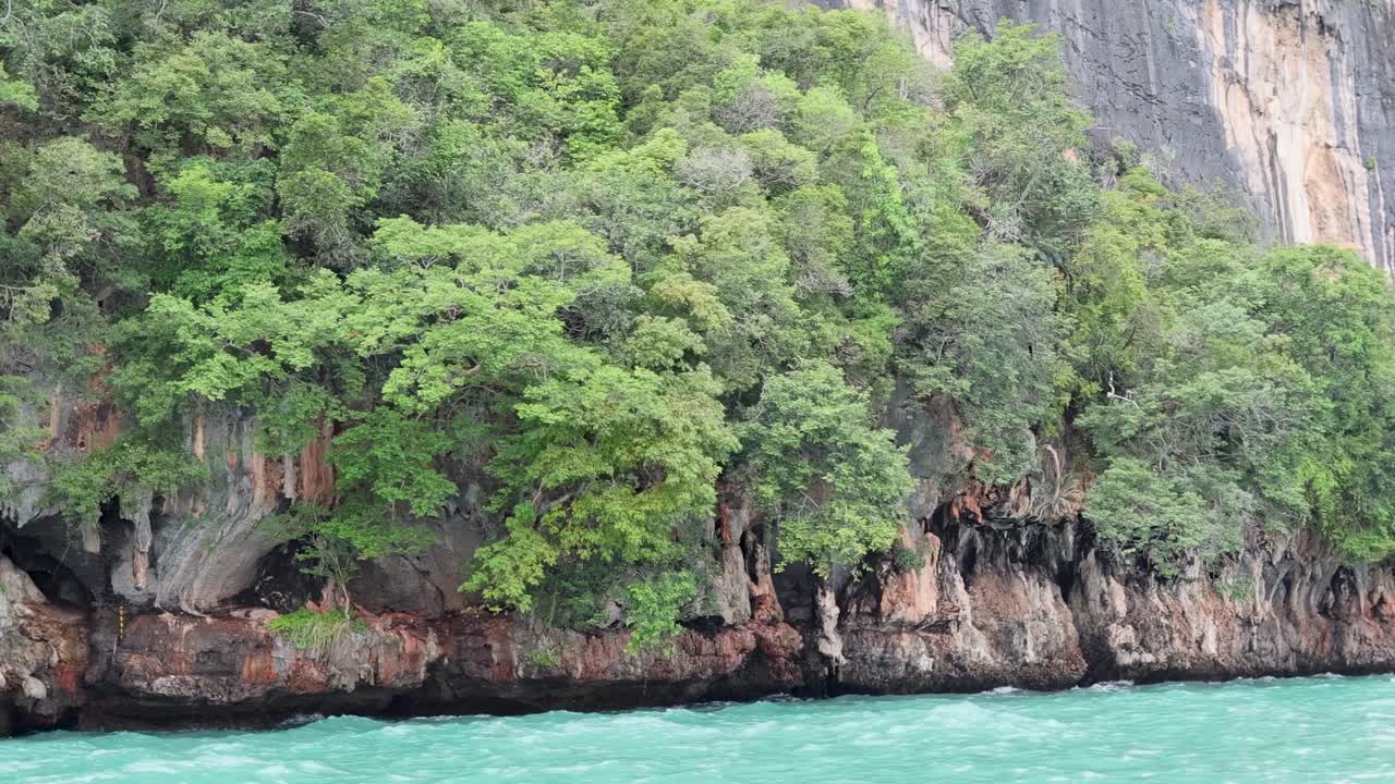 Explore vibrant green cliffs and clear turquoise waters in this stunning tropical landscape.