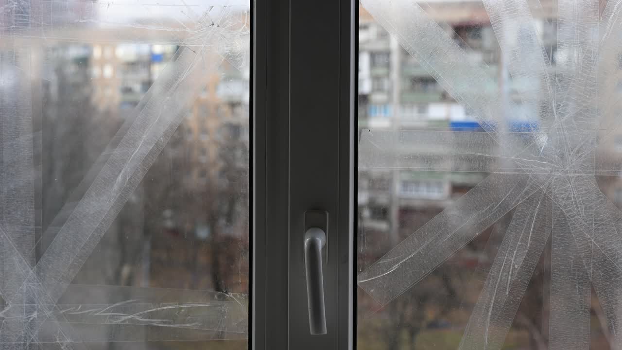 In Kramatorsk, Ukraine, a taped window vividly symbolizes civilian resilience and the enduring impact of war. This close-up highlights daily precautions amidst the ongoing Ukraine-Russia conflict.