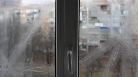 in kramatorsk, ukraine, a taped window vividly symbolizes civilian resilience and the enduring impact of war. this close-up highlights daily precautions amidst the ongoing ukraine-russia conflict.