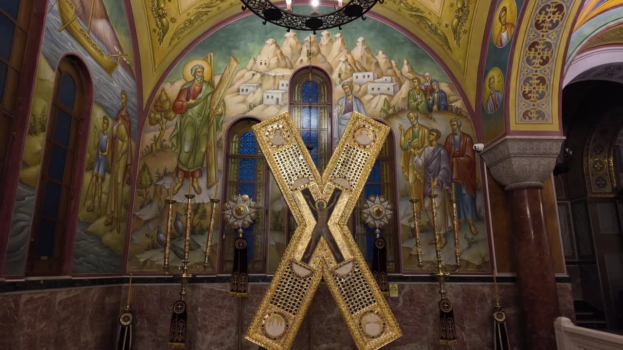 Patras,Interior of the Saint Andrew's Church,Footage starts with the chandelier hanging from the colorful dome than descending slowly towards the famous cross surrounded by colorful fresco's.No people