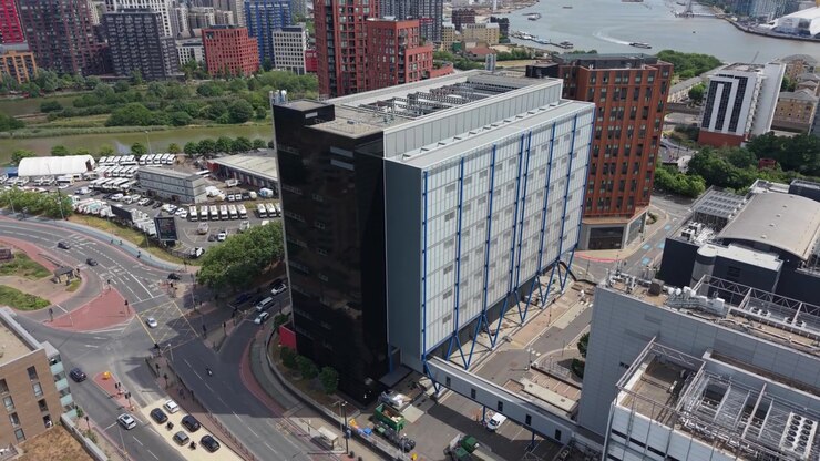 Prospettiva aerea di un moderno edificio di un data center all'interno di un vivace paesaggio urbano. I veicoli viaggiano su più strade e una rotonda