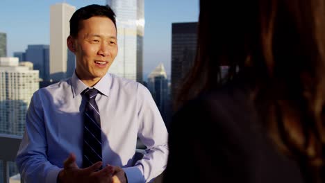 multi ethnic business couple planning strategy on rooftop