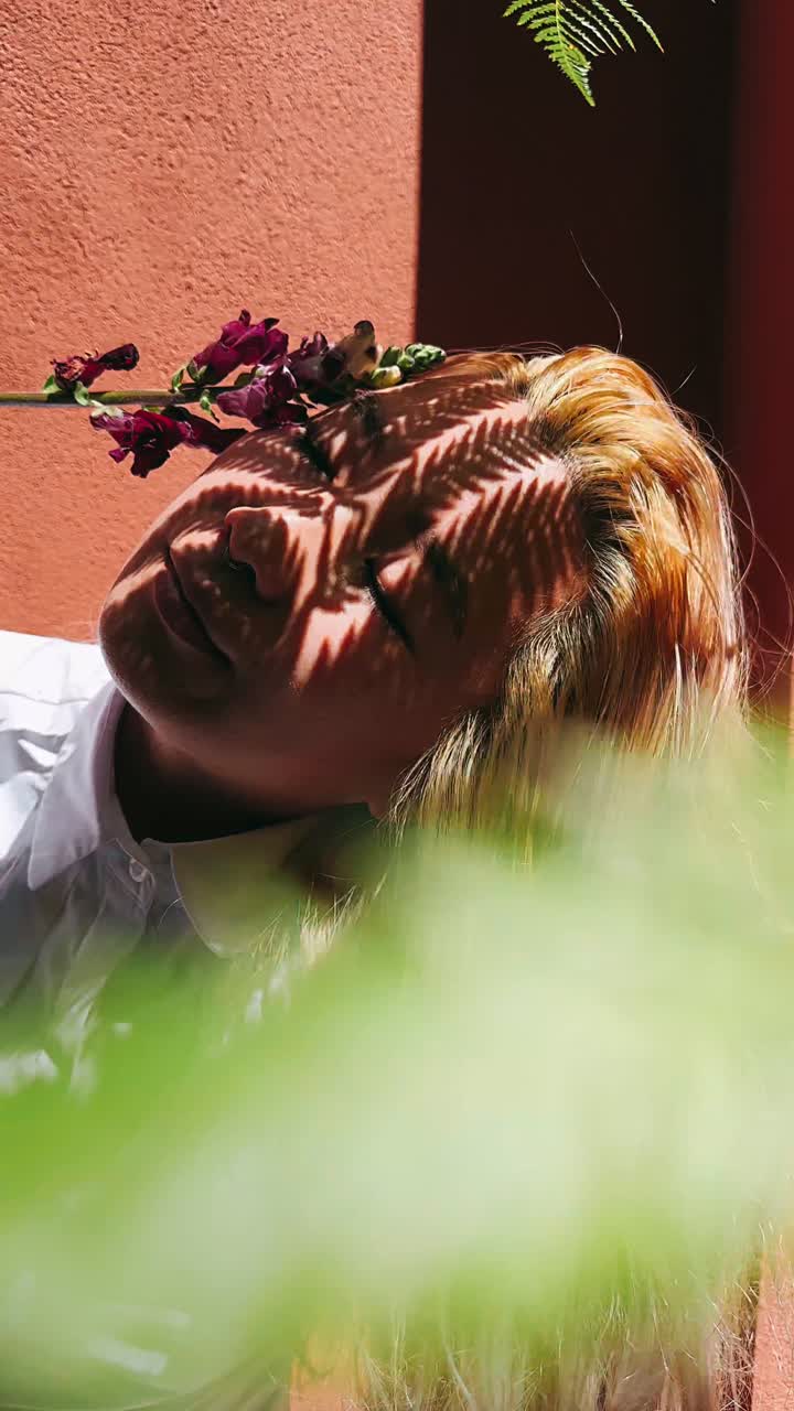 mujer con flor y sombra de helecho