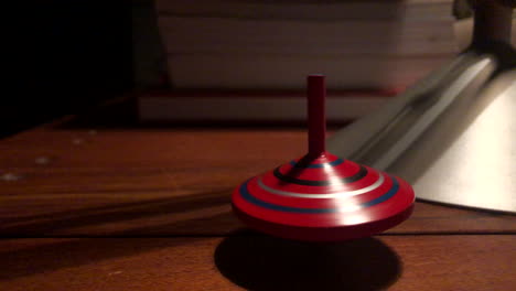 a spinning top begins to lose its energy while orbiting the office table