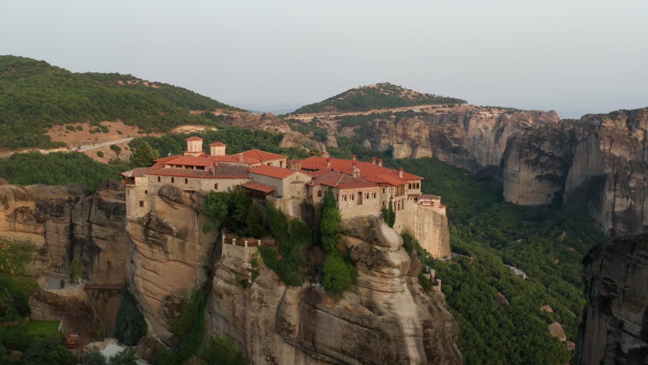 vista panorámica del monasterio de varlaam en la cima de un acantilado en meteora, grecia al atardecer