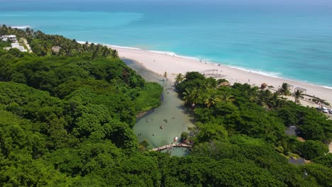 río que desemboca en una playa, el más corto del caribe, los patos, barahona, república dominicana impresionante río junto a la playa vista aérea