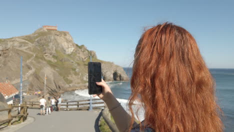 woman taking pictures on the coast