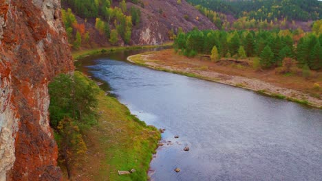 la roca con pendientes empinadas y salientes de piedra está rodeada de agua, de cerca. el río divide el bosque verde en dos partes. senderismo en las montañas, descanso en la naturaleza.