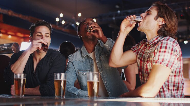 Gruppo di amici uomini che bevono cicchetti al bar