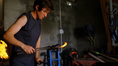 female metalsmith holding horseshoe in factory 4k