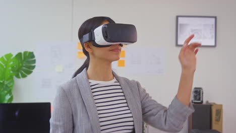 female architect in office using vr headset to design new building