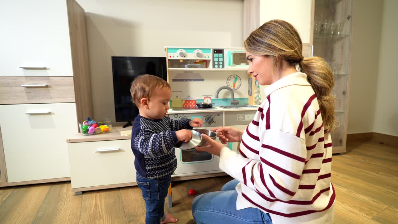 Mother and child playing in a play kitchen at home