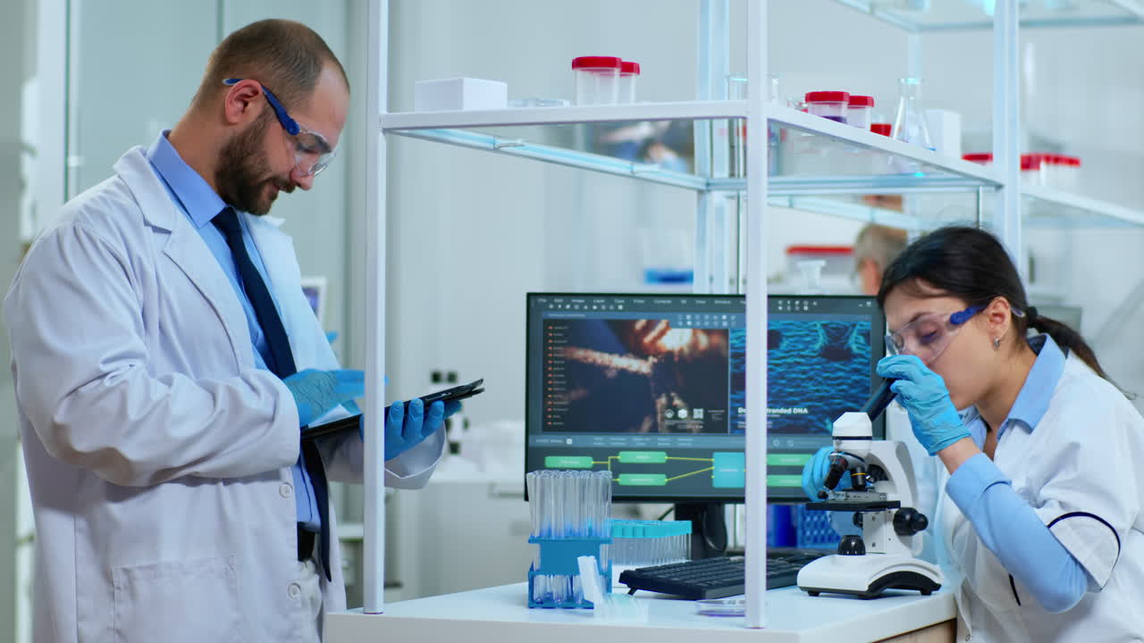 equipo de científicos que realizan investigaciones biológicas bajo el microscopio