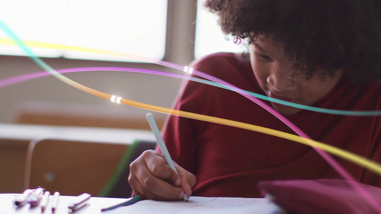 Male student placing pen, writing and completing schoolwork while light streaks sweeping foreground