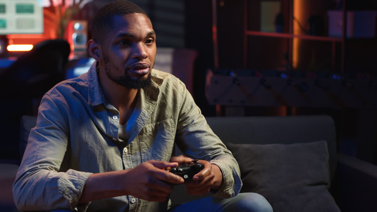 Vertical Video African american man spends free time playing video games with popcorn snack