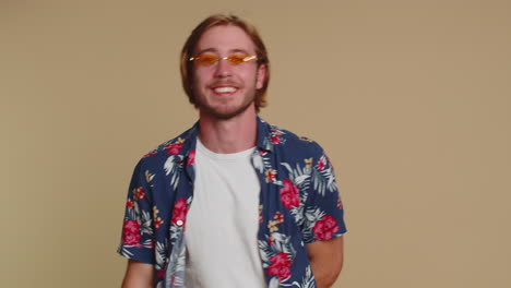 bearded man smiling friendly at camera and waving hands gesturing hello or goodbye, welcoming