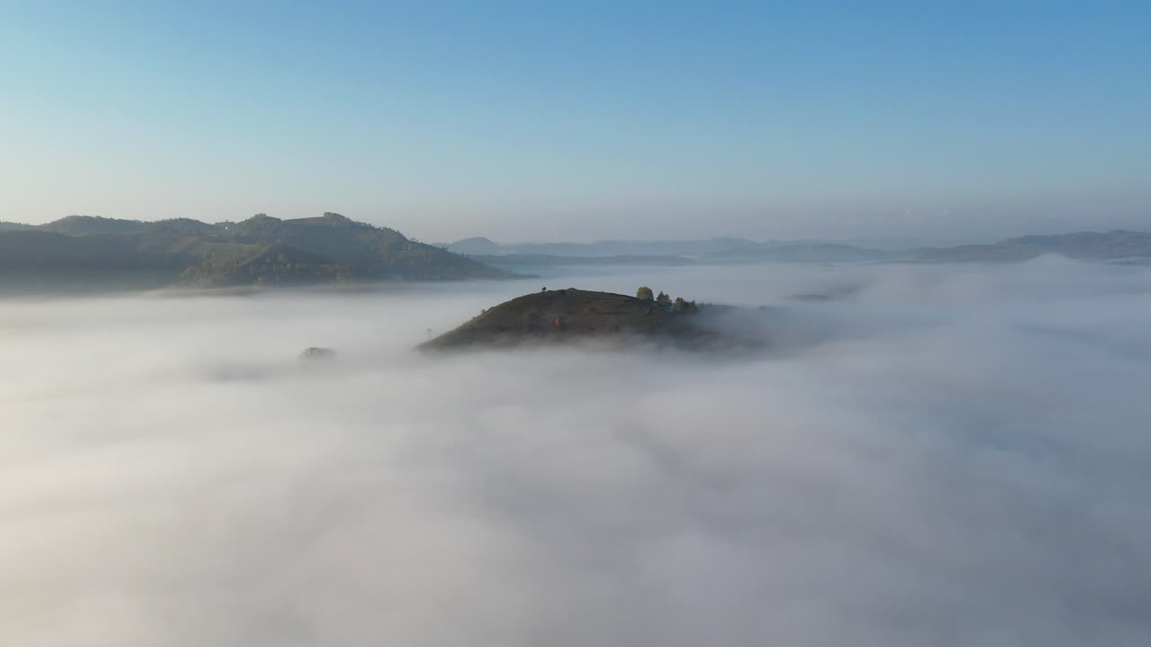 Hill top surrounded by fog in the autumn morning Romanian remote countryside. 4k aerial drone video.