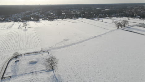 aerial of snow covered fields at the edge of rural town