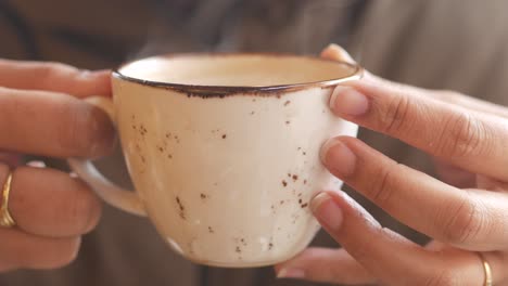 woman holding a cup of hot drink