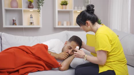 mujer dando medicina a su marido enfermo.